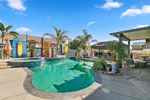 view of swimming pool featuring a pool with connected hot tub, fence, and a patio