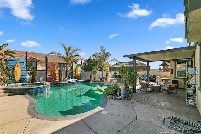 view of pool with a patio area, a pool with connected hot tub, and fence