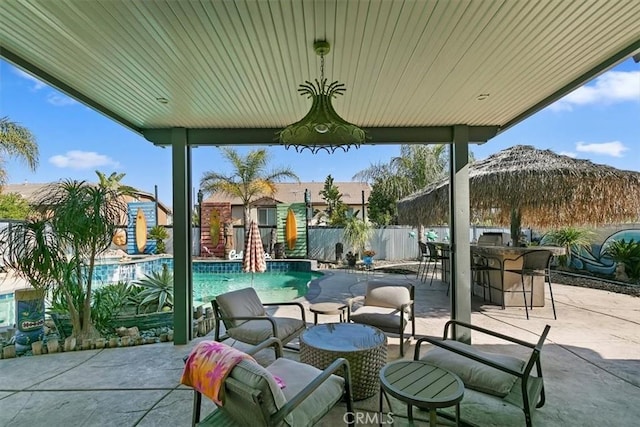view of patio featuring a fenced in pool, outdoor dry bar, and fence
