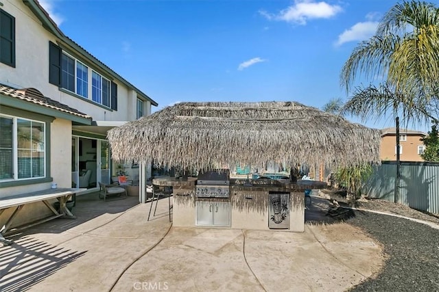 view of patio / terrace with an outdoor kitchen, a grill, and fence