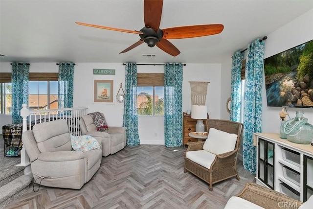 living area featuring a ceiling fan, visible vents, and a wealth of natural light