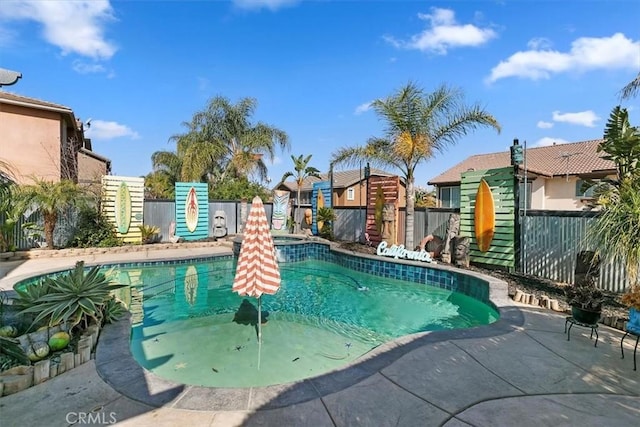 view of swimming pool featuring a fenced backyard, a pool with connected hot tub, and a patio
