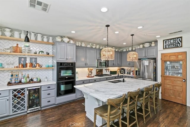 kitchen featuring visible vents, a sink, appliances with stainless steel finishes, and gray cabinets
