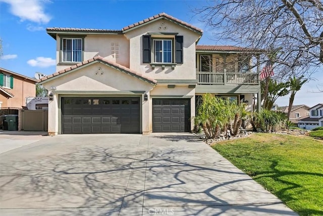 mediterranean / spanish home with concrete driveway, stucco siding, and a tile roof