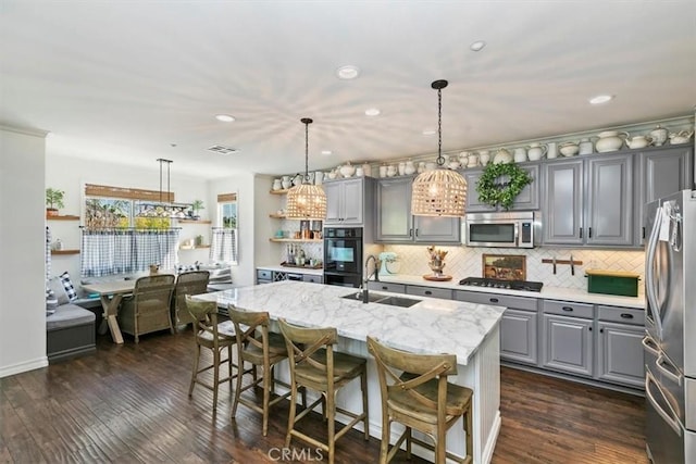 kitchen with a sink, gray cabinets, appliances with stainless steel finishes, and open shelves