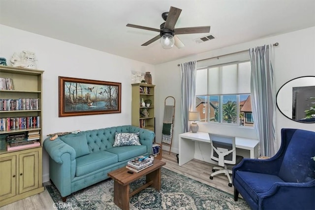 sitting room with light wood finished floors, visible vents, and ceiling fan