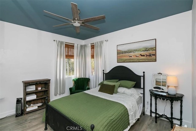 bedroom with ceiling fan, baseboards, and wood finished floors