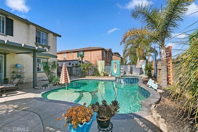 view of swimming pool featuring a fenced backyard, a pool with connected hot tub, and a patio