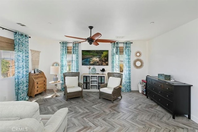 sitting room featuring visible vents, baseboards, and a ceiling fan