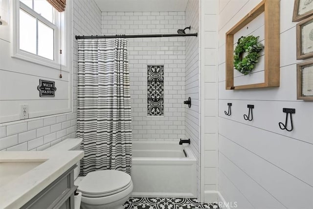 bathroom with toilet, tile walls, shower / tub combo with curtain, and vanity