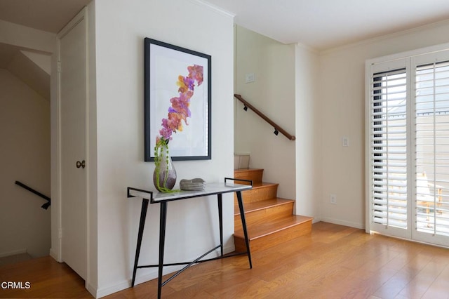 interior space featuring baseboards, ornamental molding, and wood finished floors