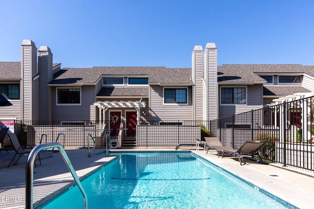 community pool featuring fence and a patio