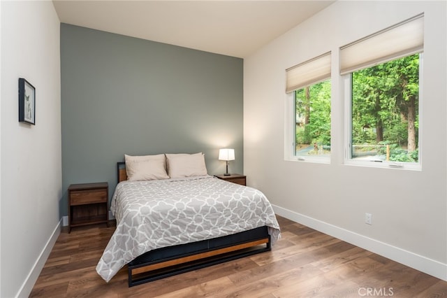 bedroom featuring baseboards and wood finished floors