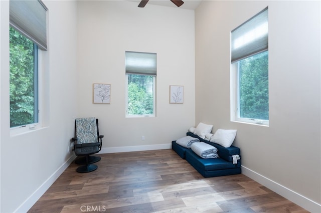 sitting room featuring baseboards, plenty of natural light, ceiling fan, and wood finished floors