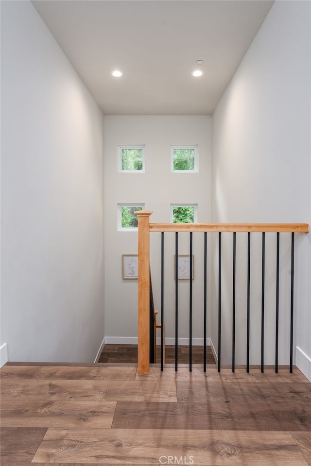 staircase with baseboards, recessed lighting, and wood finished floors