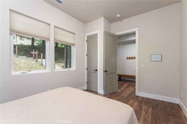 bedroom featuring baseboards, visible vents, and wood finished floors