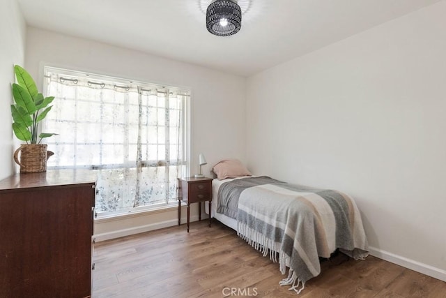 bedroom with baseboards and wood finished floors