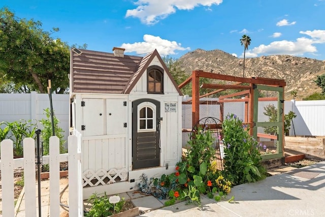 view of shed with a fenced backyard and a mountain view