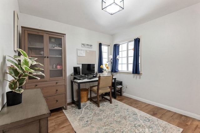 home office featuring baseboards and wood finished floors