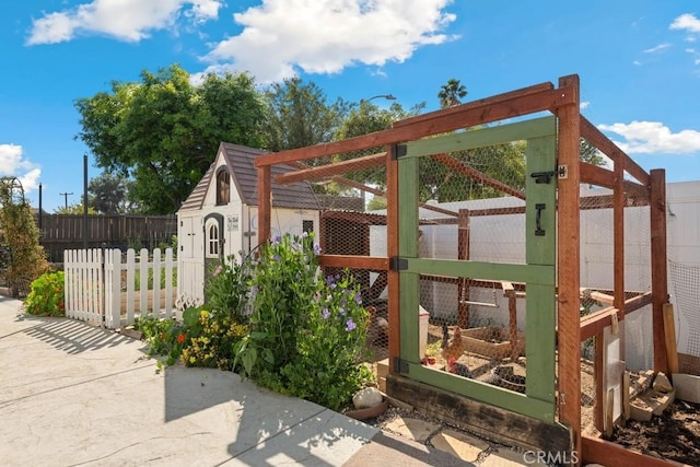view of gate featuring a fenced backyard and an outbuilding