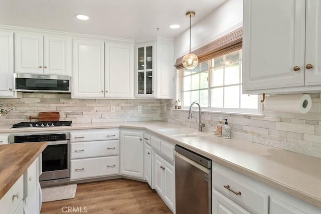 kitchen featuring a sink, appliances with stainless steel finishes, white cabinets, and butcher block counters