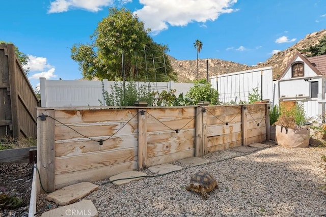 view of gate with a mountain view and fence