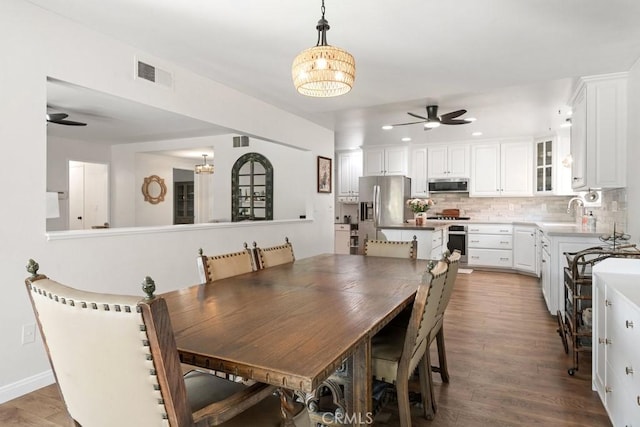 dining area featuring ceiling fan with notable chandelier, recessed lighting, baseboards, wood finished floors, and visible vents