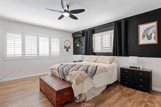 bedroom featuring a wainscoted wall, ceiling fan, and wood finished floors