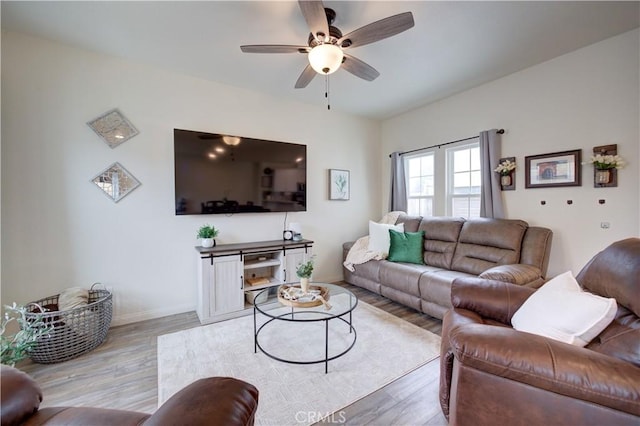 living room featuring light wood-type flooring, ceiling fan, and baseboards
