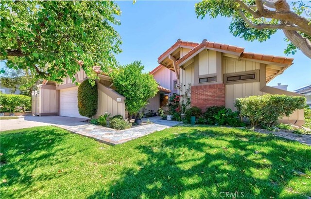 10 Mela Ln, Rancho Palos Verdes, CA 90275 - view of front of house with board and batten siding, a tile roof, a front yard, and driveway