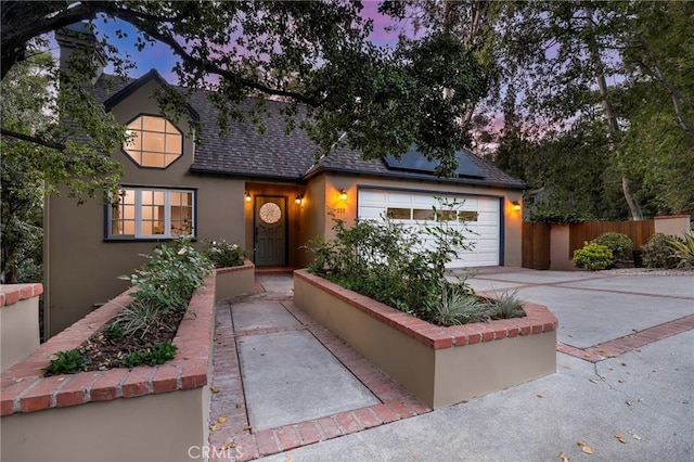 335 Sycamore Gln, Pasadena, CA 91105 - view of front of property featuring roof mounted solar panels, a garage, stucco siding, concrete driveway, and roof with shingles