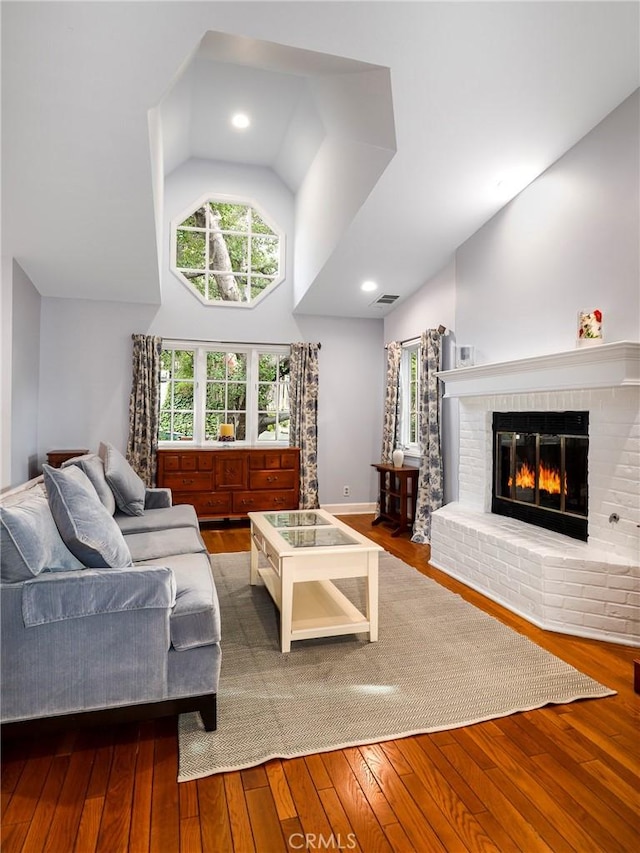 335 Sycamore Gln, Pasadena, CA 91105 - living room featuring a brick fireplace, visible vents, hardwood / wood-style floors, and high vaulted ceiling