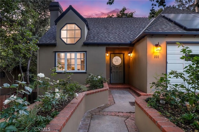 335 Sycamore Gln, Pasadena, CA 91105 - exterior entry at dusk featuring a shingled roof, stucco siding, and a chimney