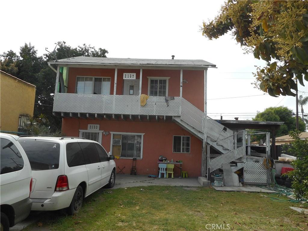 back of property with stairway and a lawn