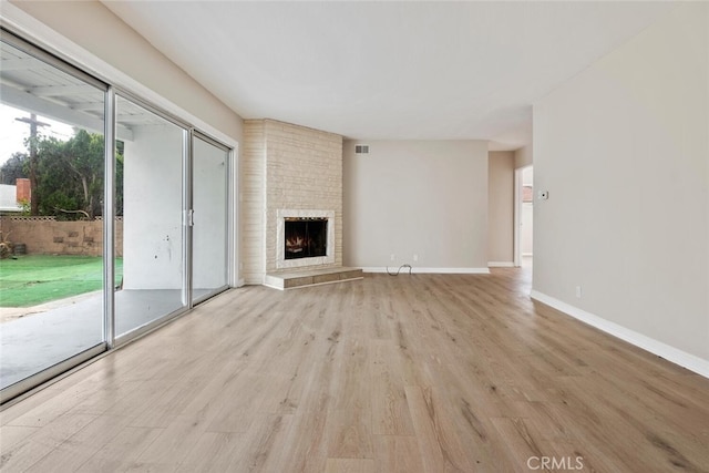 8856 Fullbright Ave, Winnetka, CA 91306 - unfurnished living room featuring visible vents, baseboards, a large fireplace, and light wood-style floors