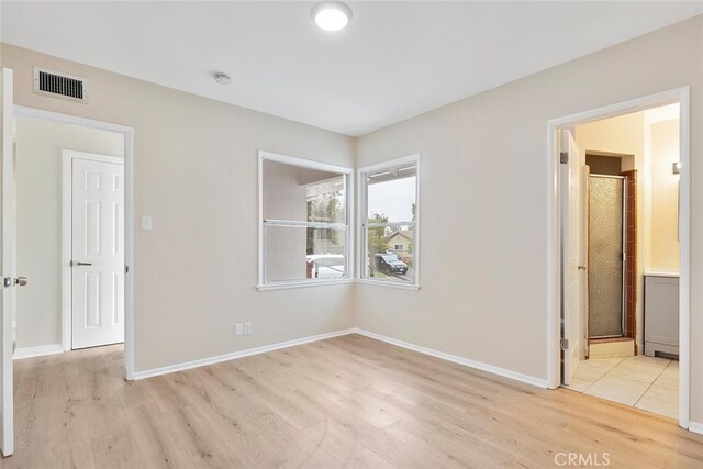 8856 Fullbright Ave, Winnetka, CA 91306 - unfurnished bedroom featuring light wood-type flooring, baseboards, visible vents, and connected bathroom