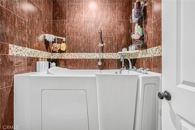 clothes washing area with tile walls