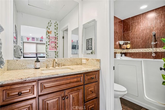 bathroom featuring vanity, a shower, toilet, and wood finished floors