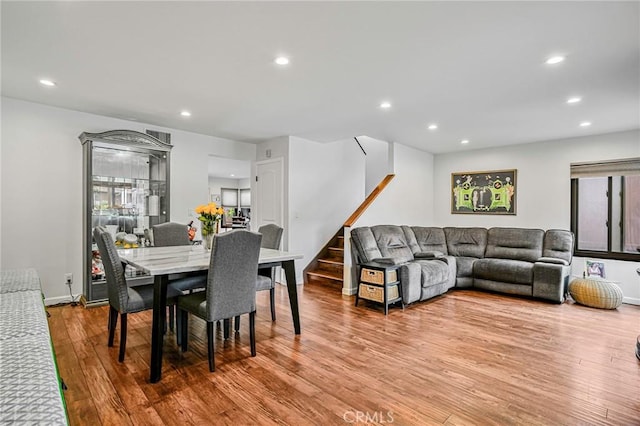 dining space featuring recessed lighting, baseboards, stairs, and wood finished floors