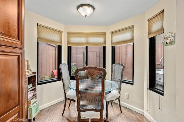 dining area with baseboards and light wood-style floors