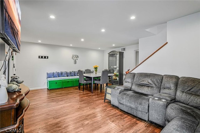living room featuring recessed lighting, baseboards, wood finished floors, and visible vents