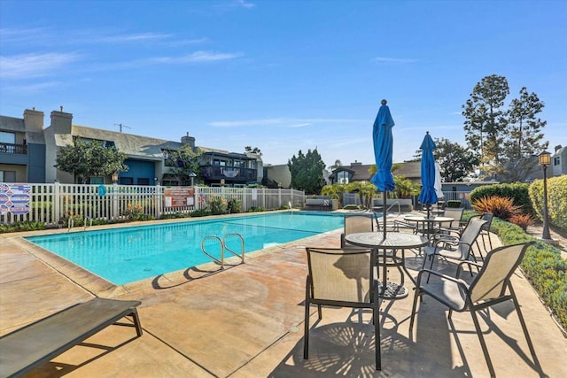 community pool with fence and a patio
