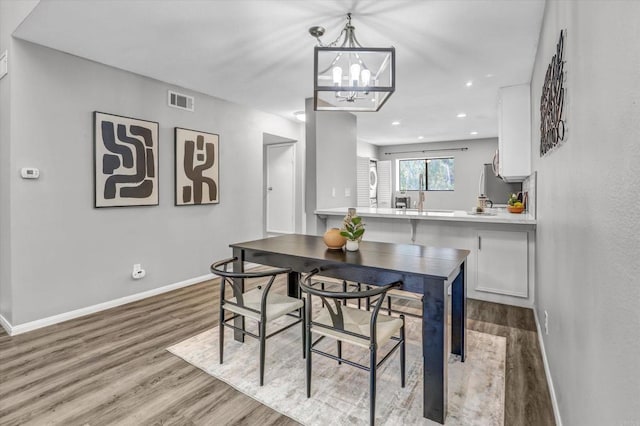 dining area with visible vents, wood finished floors, baseboards, recessed lighting, and a chandelier