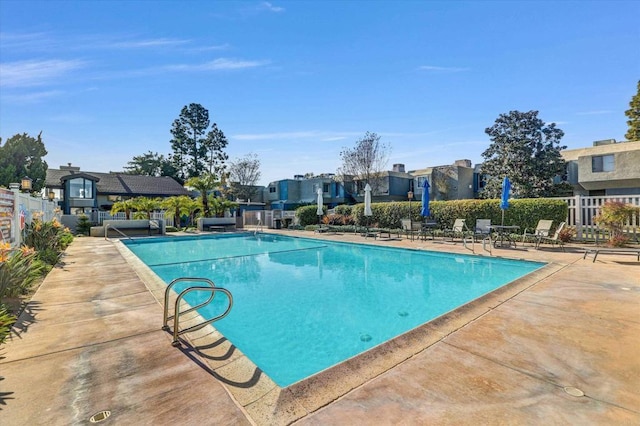 pool with fence and a patio area