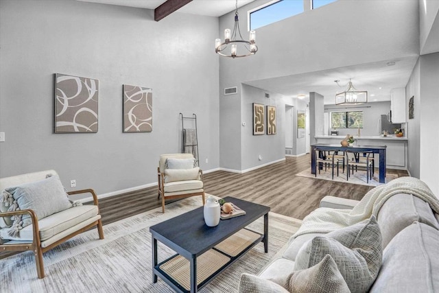 living room featuring an inviting chandelier, wood finished floors, and a wealth of natural light