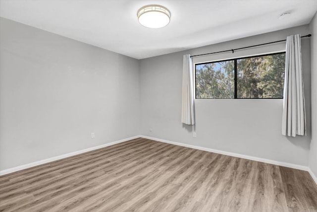 unfurnished room featuring baseboards and wood finished floors