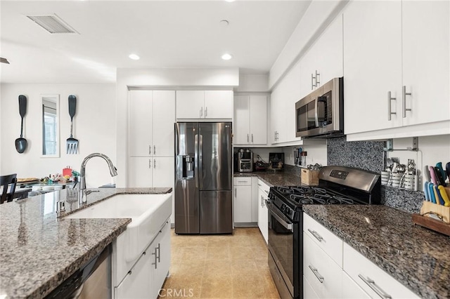 45477 Calle Cirros, Temecula, CA 92592 - kitchen with stainless steel appliances, dark stone countertops, a sink, recessed lighting, and white cabinetry