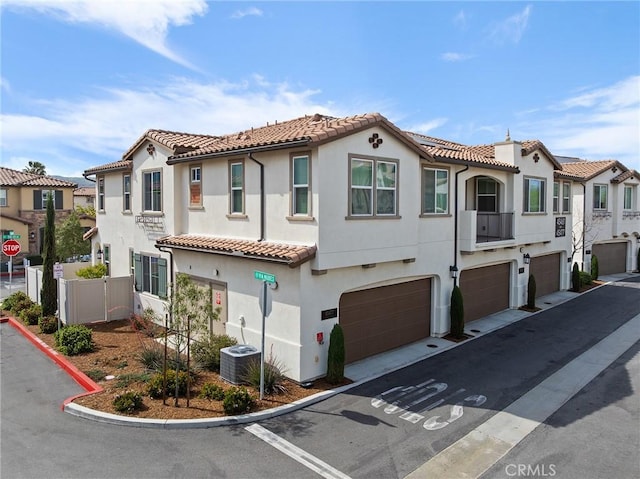 45477 Calle Cirros, Temecula, CA 92592 - view of front of house featuring a garage, stucco siding, a tiled roof, and a residential view
