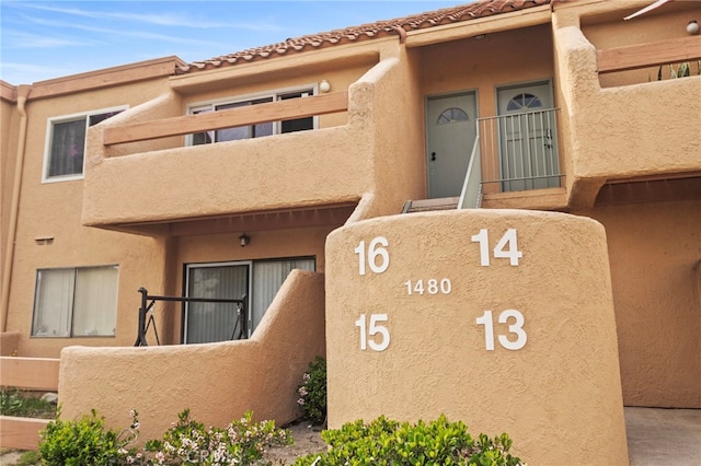 doorway to property featuring stucco siding and a balcony