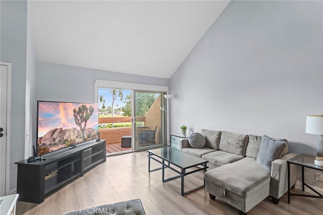 living room featuring wood finished floors and vaulted ceiling